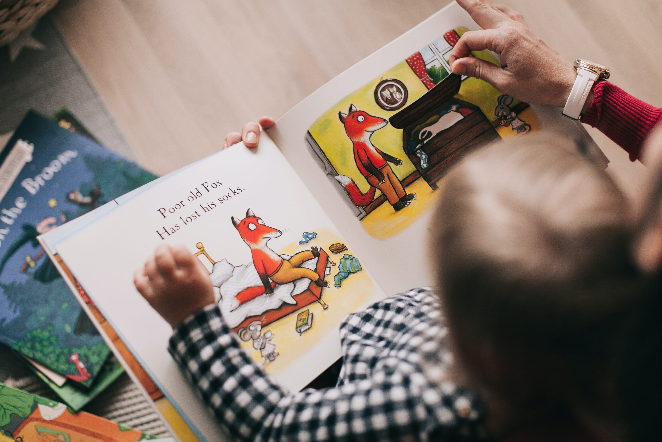 Child reading book with carer generic